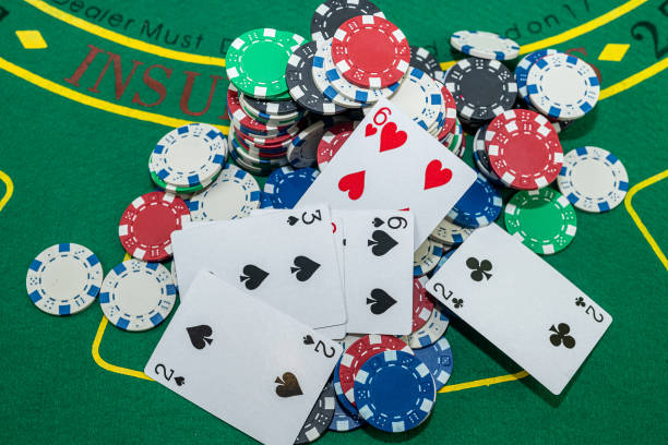 istock poker chips with playing cards on green casino table. 1445705559