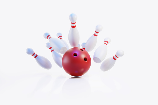 Red bowling ball hitting pins in the bowling alley on white background. Horizontal composition with copy space. Bowling concept.