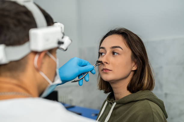 istock ENT doctor examines the patient's nose using an otoscope. 1445707300