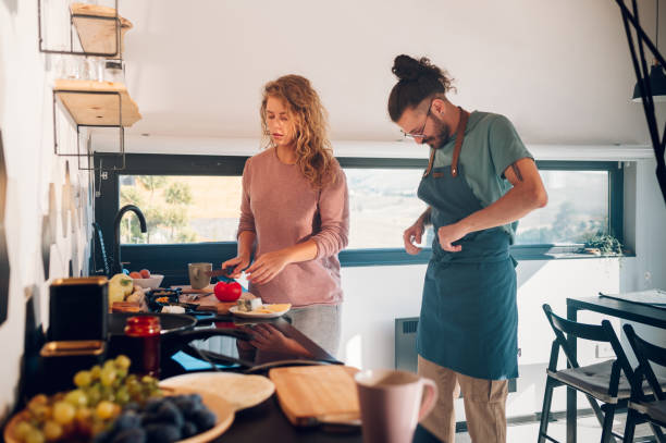 istock Young couple making breakfast together in the kitchen at home 1445708469