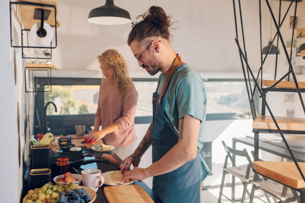 istock Young couple making breakfast together in the kitchen at home 1445708470