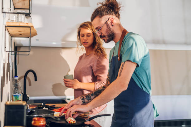 istock Young couple making breakfast together in the kitchen at home 1445708476