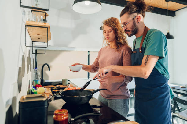 istock Young couple making breakfast together in the kitchen at home 1445708478