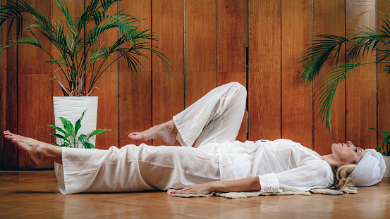 Woman practicing Kundalini Yoga, Kriya exercises for the navel center and bowel waste elimination