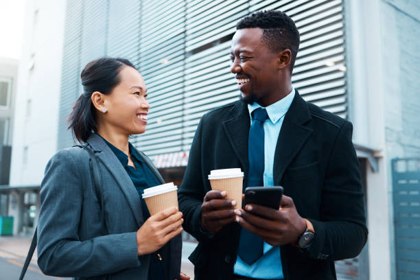istock Business employees, get coffee outside together before work begins and colleagues start working. Friends travel to urban job, walking in the city and talking while drinking takeaway drinks 1445710121