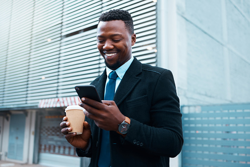 Coffee, social media and businessman on his phone in the city of Singapore with smile in morning. Happy, corporate and African employee reading chat on mobile phone with drink of tea and 5g internet