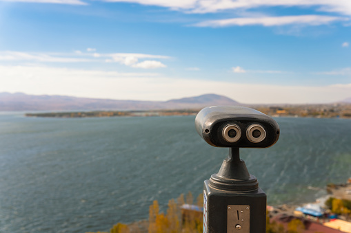 Binoculars in front of the open-air lake