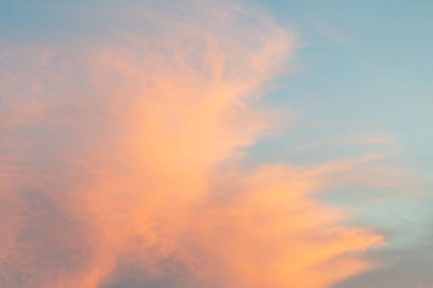 istock Orange tinted  clouds on blue sky at sunset. 1445715585