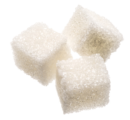 Three white sugar cubes on white background. Macro picture.