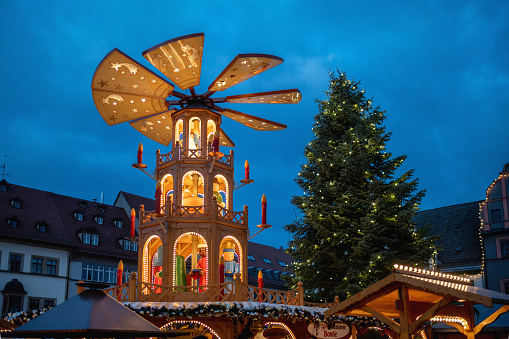 illuminated public christmas market with pyramid and decorated tree in the historic town of weimar, germany