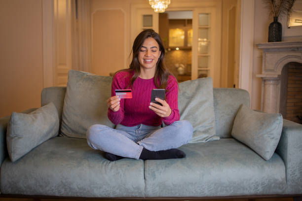 istock Cheerful  woman doing online shopping 1445732648
