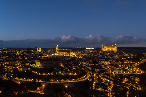 Night photo of the city of Toledo in Spain.  Toledo Cathedral and Alcazar de Toledo illuminated.  Night photo of the main streets and monuments of Toledo in Spain.  Historical buildings of Spain.
