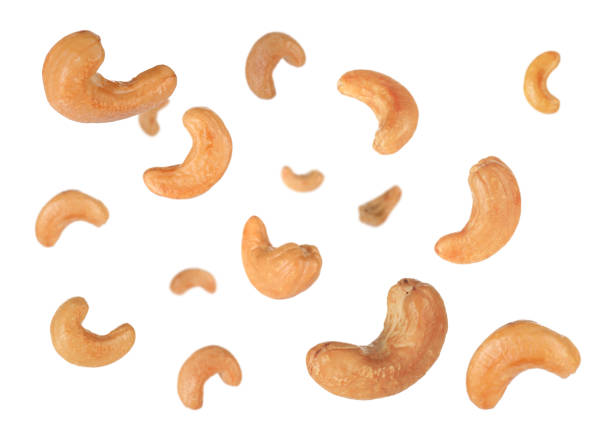 istock Tasty roasted cashew nuts falling on white background 1445738281