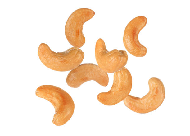 istock Tasty roasted cashew nuts falling on white background 1445738282
