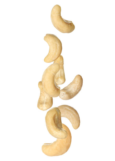 istock Tasty raw cashew nuts falling on white background 1445738319