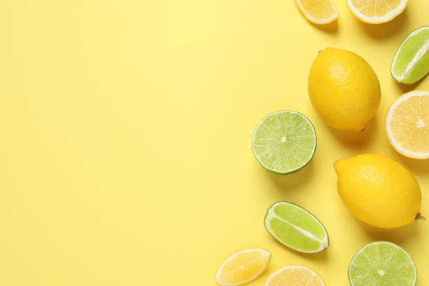 istock Fresh ripe lemons and limes on yellow background, flat lay. Space for text 1445738501