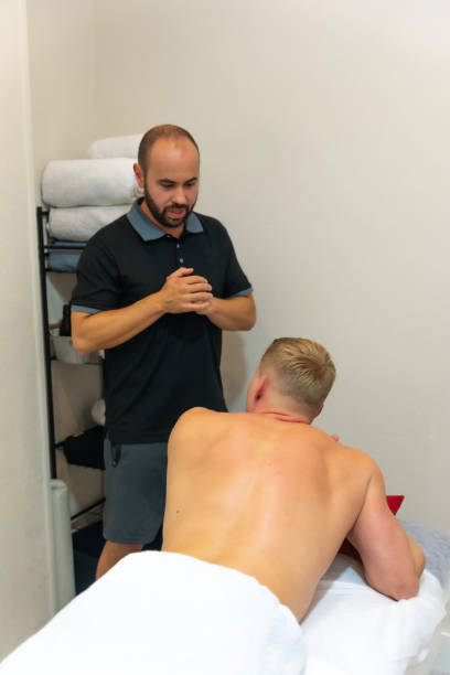 istock Physiotherapist talking to client before physiotherapy massage 1445739647