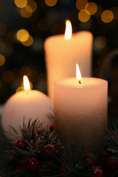 istock Beautiful burning candles against Christmas lights, closeup 1445742375
