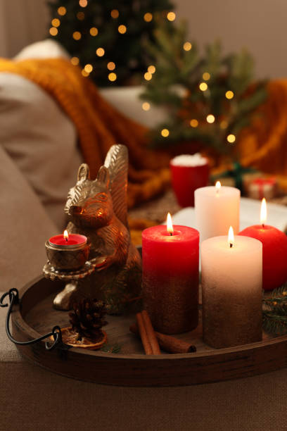 istock Tray with beautiful burning candles and Christmas decor on sofa at home 1445742649
