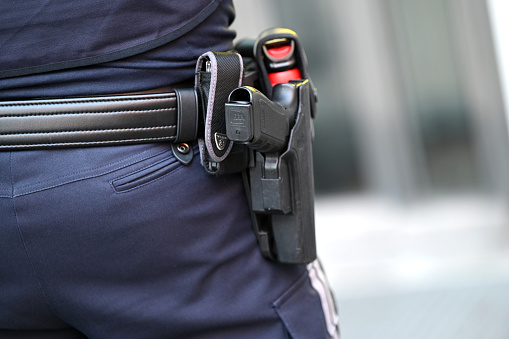 Detail shot of a police pistol of a police woman from behind Vienna, Austria