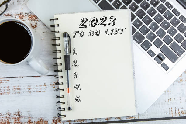 to-do-liste 2023 text auf notizblock mit laptop auf holzhintergrund - determination new years eve list calendar stock-fotos und bilder