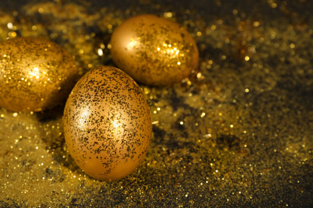 istock Shiny golden eggs with glitter on dark table, space for text 1445744770