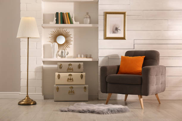 istock Stylish room interior with comfortable armchair and storage trunks near white wall 1445748017