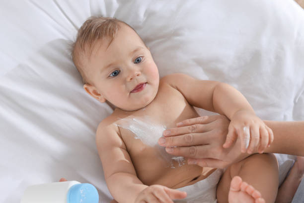 istock Mother applying dusting powder onto her baby on bed, top view 1445748254