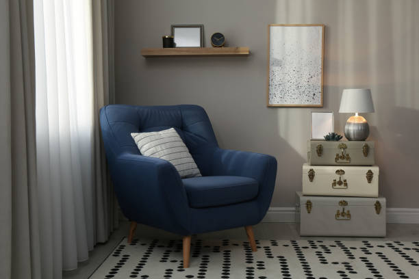 istock Stylish room interior with comfortable armchair and storage trunks near grey wall 1445748911