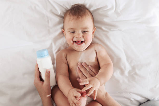 istock Mother applying dusting powder onto her baby on bed, top view 1445749211