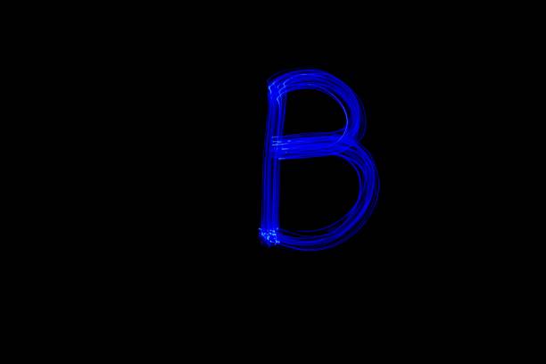 Light painting blue letter B on black background. Long exposure photo.