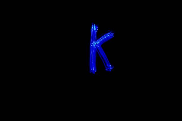 istock Light painting blue letter K on black background 1445749793