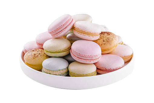Multicolored macaroons on ceramic plate isolated on white