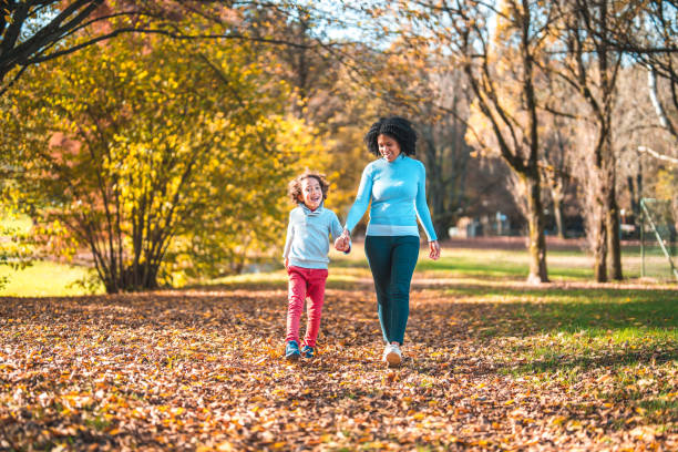 istock Hispanic Mother And Her Young Boy Holding Hands While Walking In A Public Park 1445757171