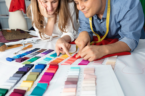 Fashion designers are choosing fabric and color for their new collection.