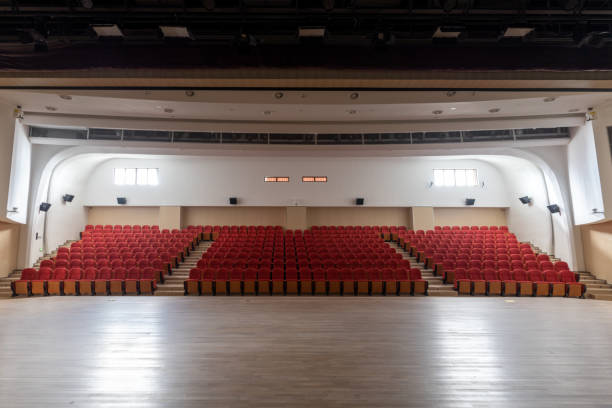 uma fileira de cadeiras vermelhas arrumadas no teatro inacabado - lecture hall auditorium university empty - fotografias e filmes do acervo