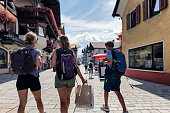 Mother and teenage kids sightseeing old town streets of St Johann in Austria