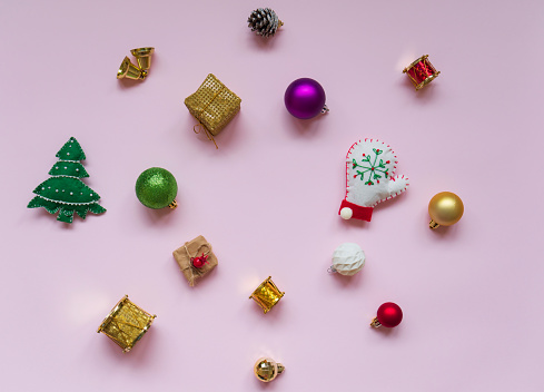 Christmas decoration made with ornaments on pink background