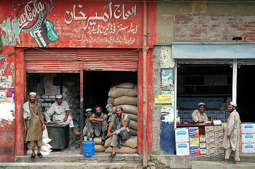 Landi Kotal, Khyber Pass, Khyber Pakhtunkhwa / Pakistan - Aug 16 2005: Local Muslim men outside two stores in Landi Kotal, Pakistan. One shop advertises Coca Cola. Landi Kotal is on the Khyber Pass.