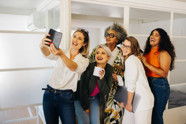 Happy business team taking a group selfie in an office