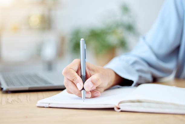 istock Woman hands, writing notebook and planning ideas at receptionist desk in startup. Closeup writer, journalist and secretary of schedule, agenda planner and strategy reminder, budget notes and analysis 1445771054