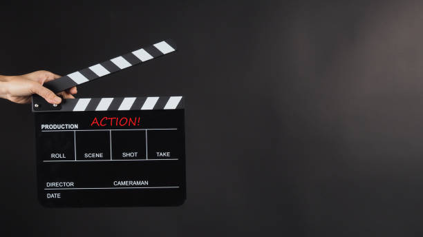 istock Hand is holding Black clap board on black background.It have word action. 1445775476