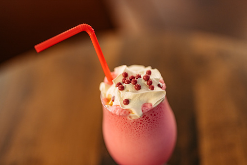 Close-up of a strawberry milkshake on the table in a café.