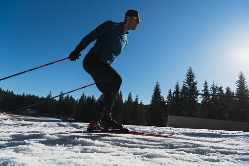 Girl is traversing down the slope of fresh snow powder