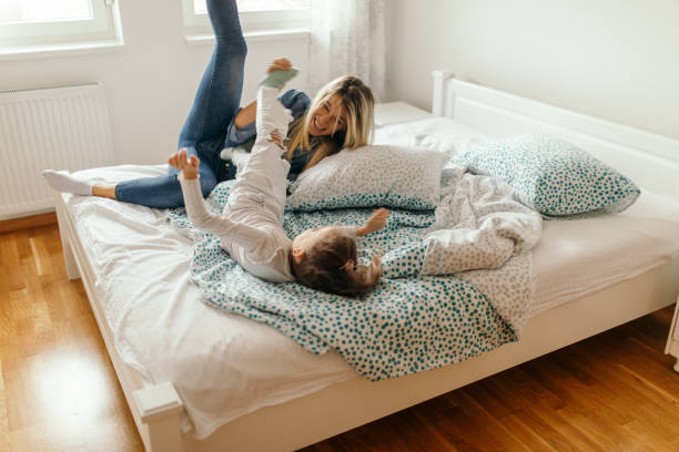istock Woman spending some great time with little girl at home and playing in bedroom 1445783473