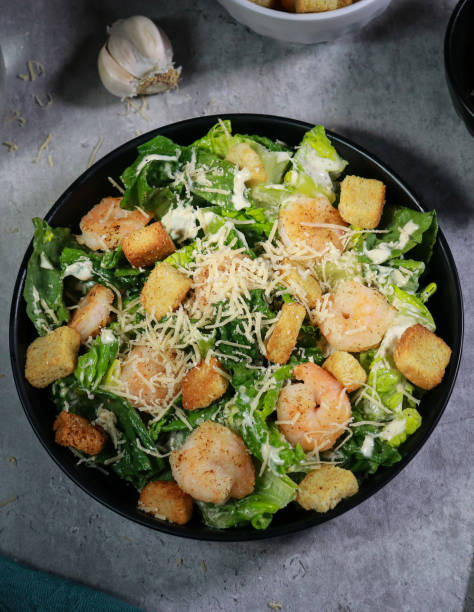 istock Cesar salad with grilled shrimp, croutons and parmesan cheese on grey marble table 1445785041