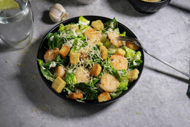 istock Cesar salad with grilled shrimp, croutons and parmesan cheese on grey marble table 1445785113