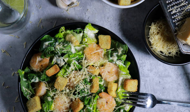 istock Cesar salad with grilled shrimp, croutons and parmesan cheese on grey marble table 1445785175