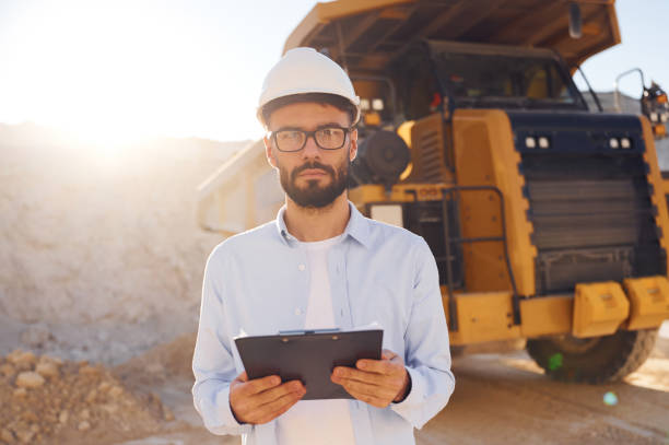 istock In hard hat, eyewear and with notepad. Man in uniform is working in the quarry at daytime 1445785333