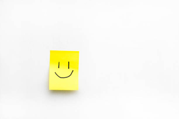 istock Small note on yellow paper with a drawn face 1445789050